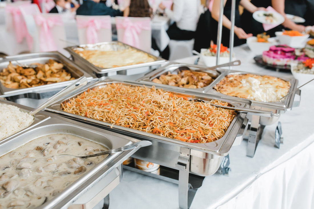 catered food in chafing dishes on buffet table at formal party
