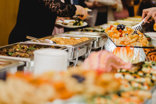 Buffet table with various dishes helping guests calculate amount of food for your self catered wedding reception