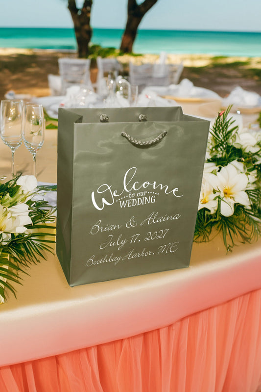 Elegant wedding welcome bags on a beautifully set table near the beach for a memorable celebration