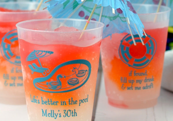 Personalized favor cups with colorful designs and umbrellas for a fun pool party celebration