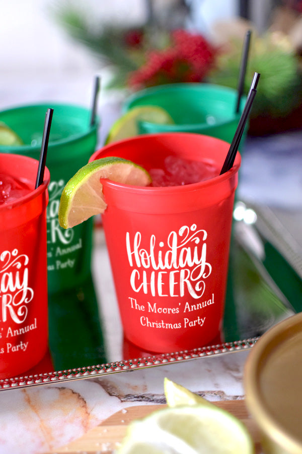 Red 12 oz. stadium cups personalized with 'Holiday Cheer' Christmas design and 2 lines of custom text in white imprint color