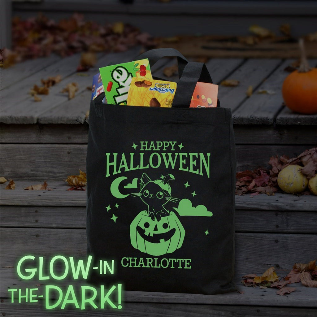 Black glow in the dark tote showing a cat in pumpkin personalized trick or treat bag design filled with candy