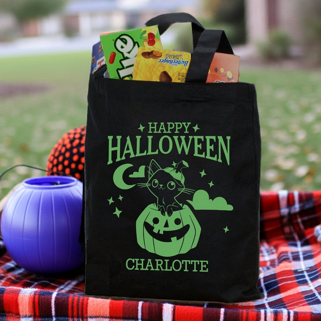 Black Halloween tote showing green cat in pumpkin personalized trick or treat bag graphic with candy inside