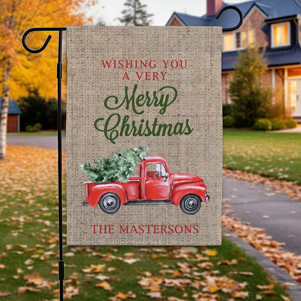 Christmas garden flag featuring a red truck with a Christmas tree and festive message for holiday decor