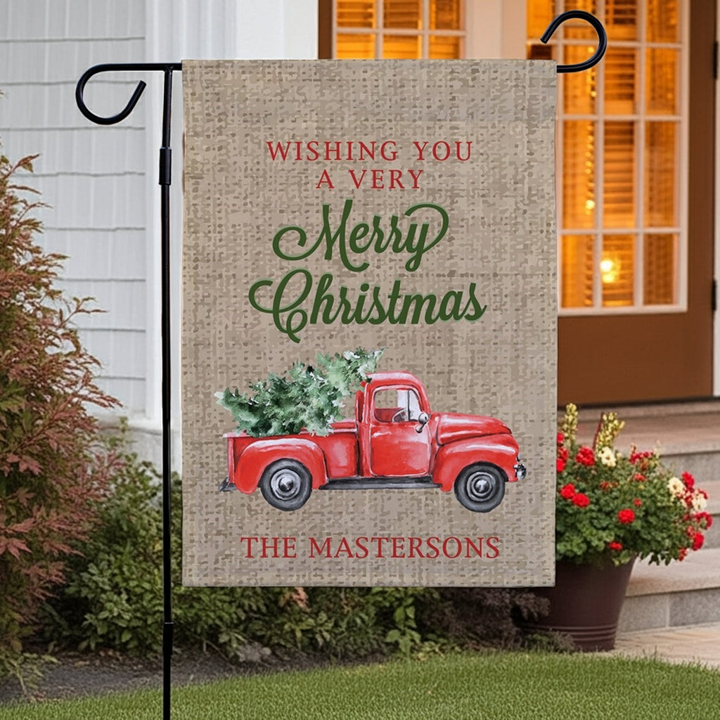 Christmas garden flag featuring a vintage red truck with a Christmas tree and cheerful greetings