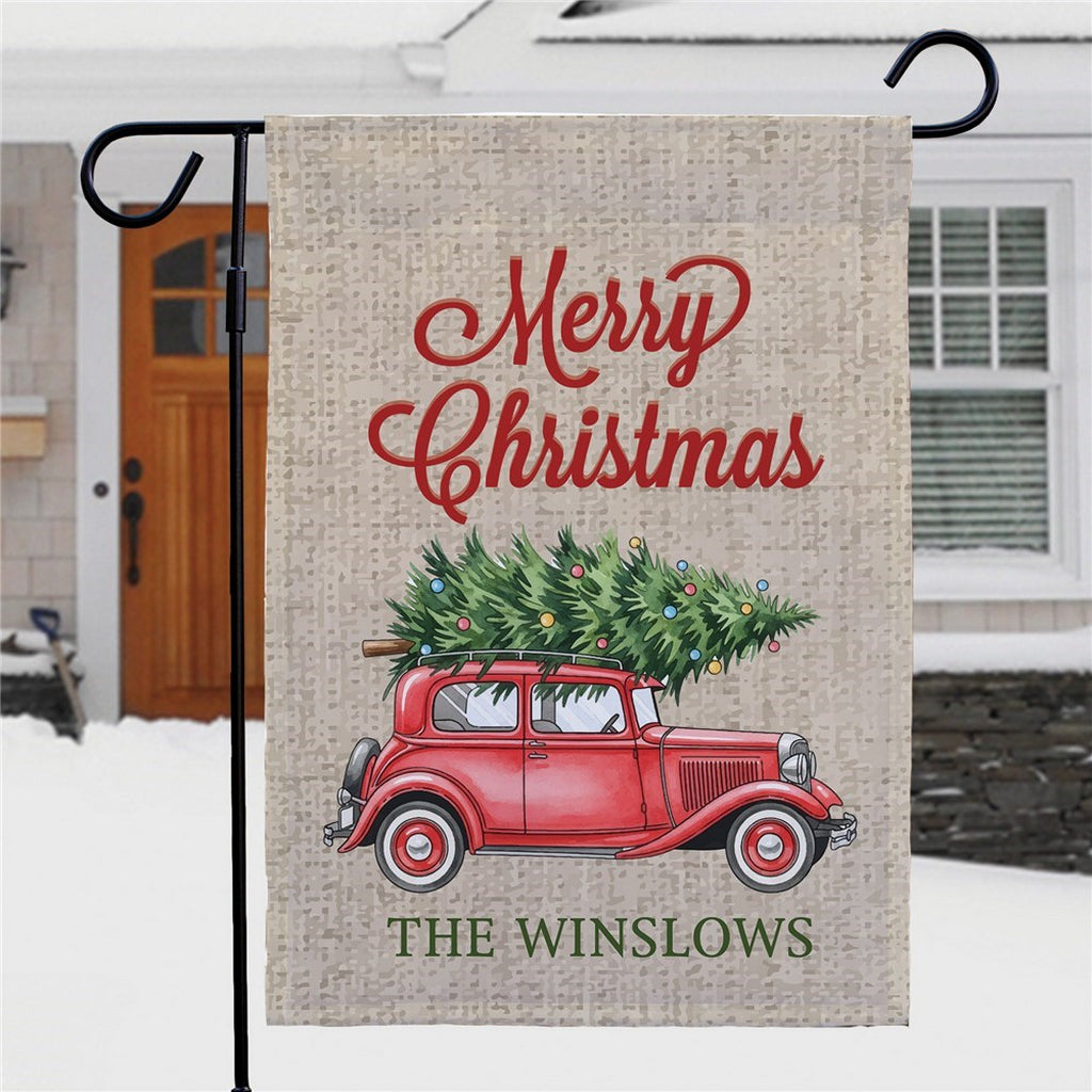 Christmas garden flag featuring a red car with a Christmas tree and the text Merry Christmas