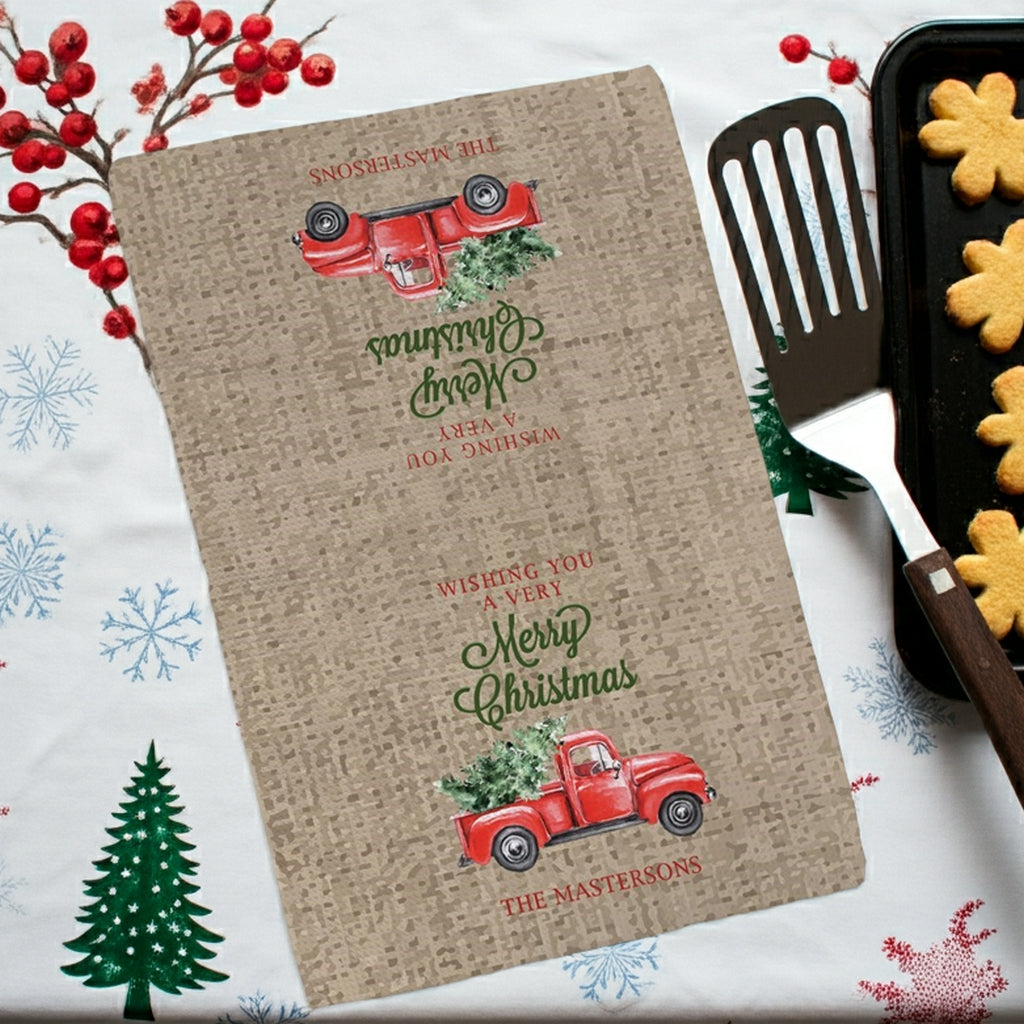 Christmas kitchen towel personalized with family name featuring a festive red truck and the phrase wishing you a very Merry Christmas