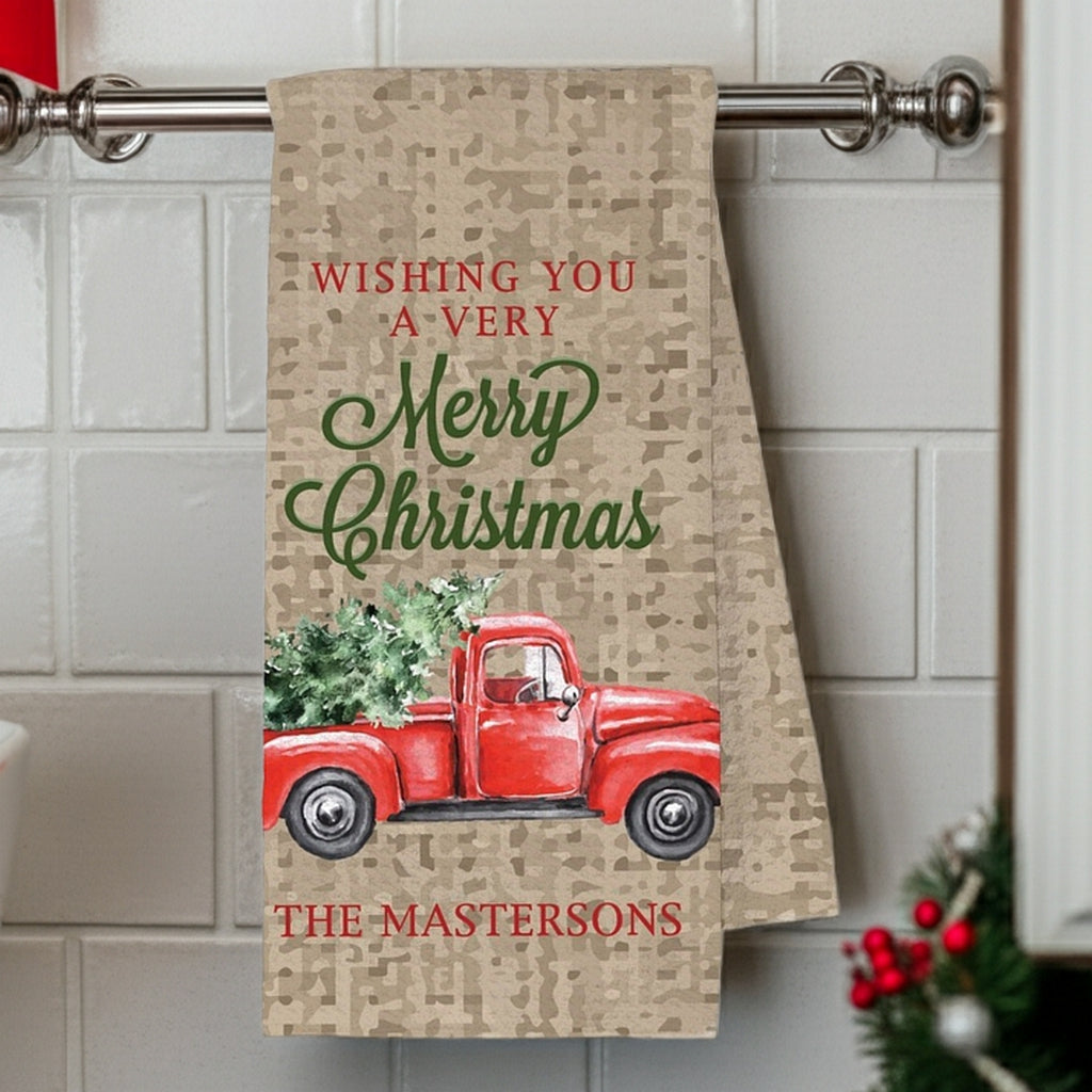 Christmas kitchen towel featuring a red truck and festive holiday wishes personalized with family name