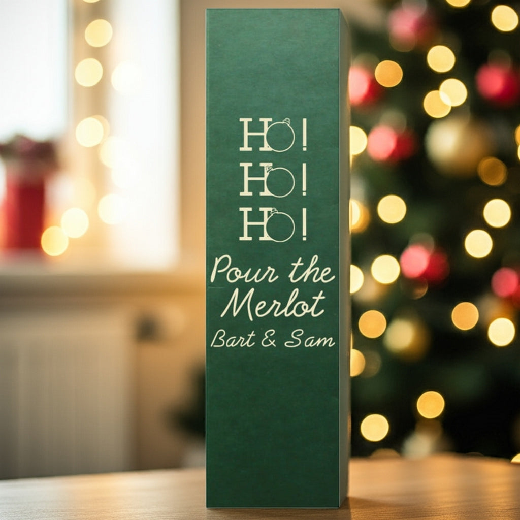 Tippytoad green wine bottle bag reading Ho Ho Ho Pour the Merlot beside tree custom printed Christmas wine bottle gift boxes