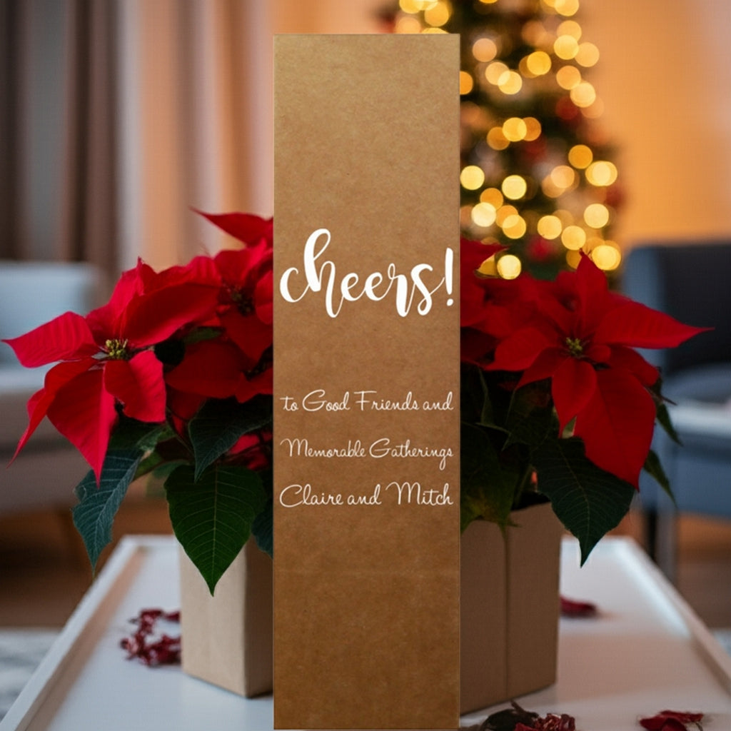 Tippytoad kraft wine bottle bag reading cheers among poinsettias and tree lights custom printed Christmas wine bottle gift boxes
