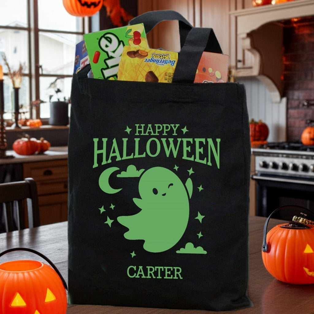 Black tote with glow in the dark ghost personalized trick or treat bag reading Happy Halloween and Carter