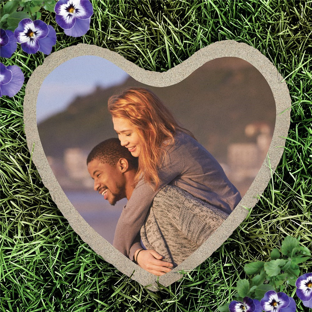 Heart shape custom photo garden stone with a couple photo on grass surrounded by purple flowers