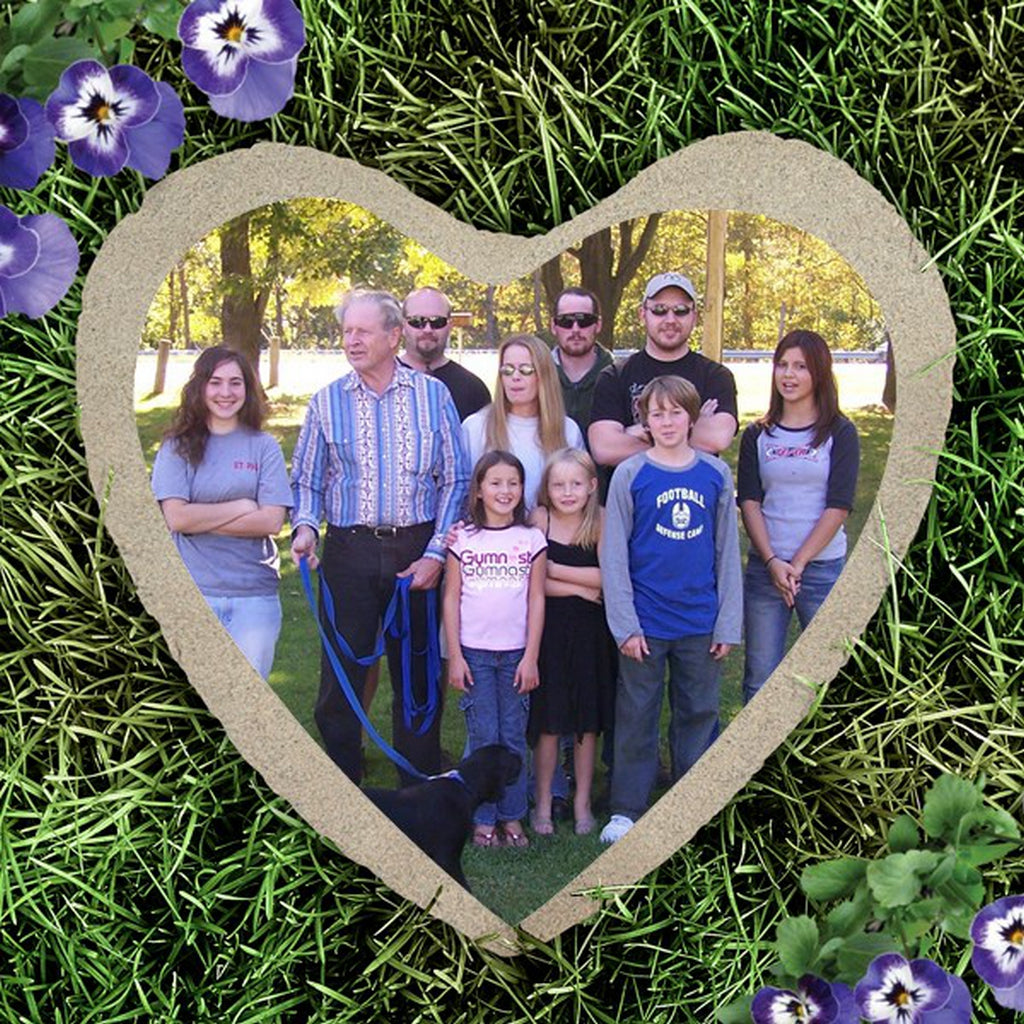 Heart shape custom photo garden stone featuring a family portrait on grass background
