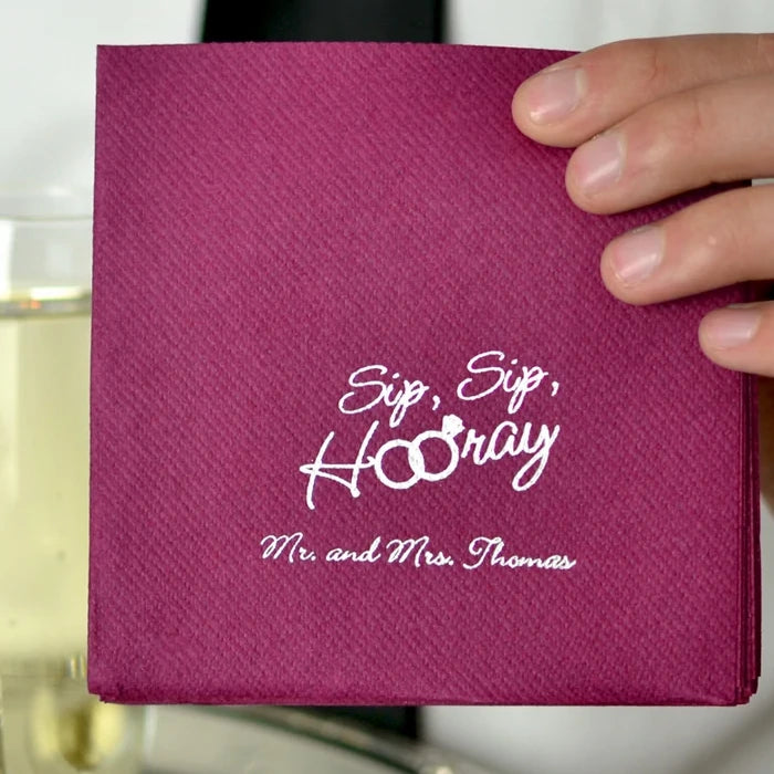 Person holding custom printed premium linen feel cocktail napkins for serving wedding drinks