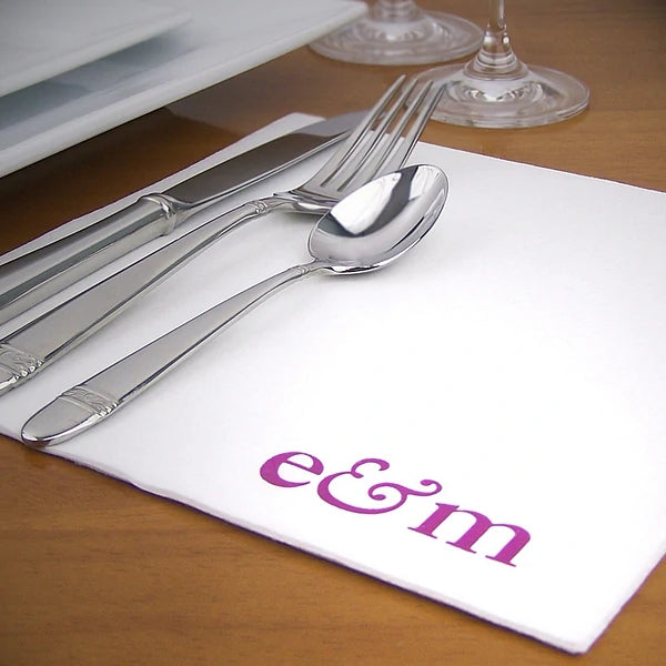 White linen feel wedding dinner napkins custom printed with bride and groom initial monogram at dinner table place setting
