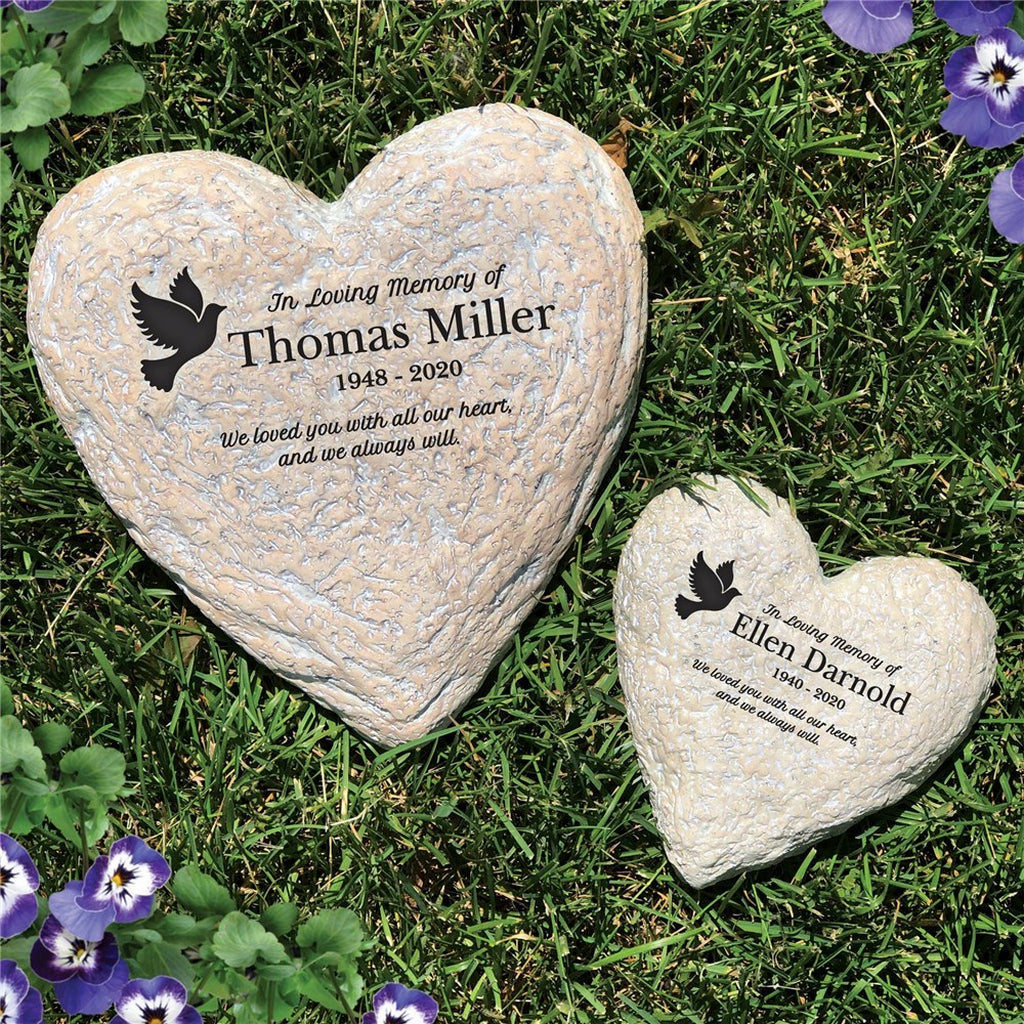 Heart-shaped personalized memorial garden stones with engraved names and message on grass with purple flowers