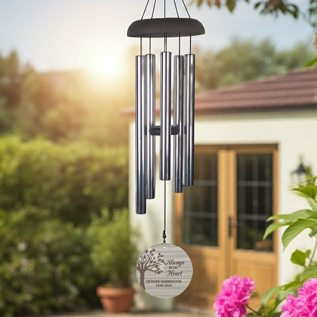 Personalized memorial wind chime with silver tubes and engraved wooden heart hanging outdoors