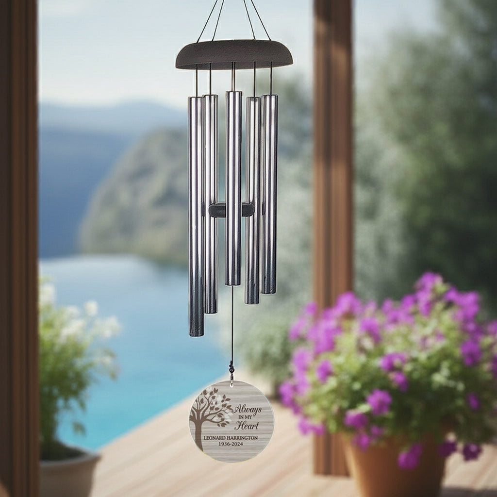 Personalized memorial wind chime hanging outdoors with engraved tribute and silver tubes
