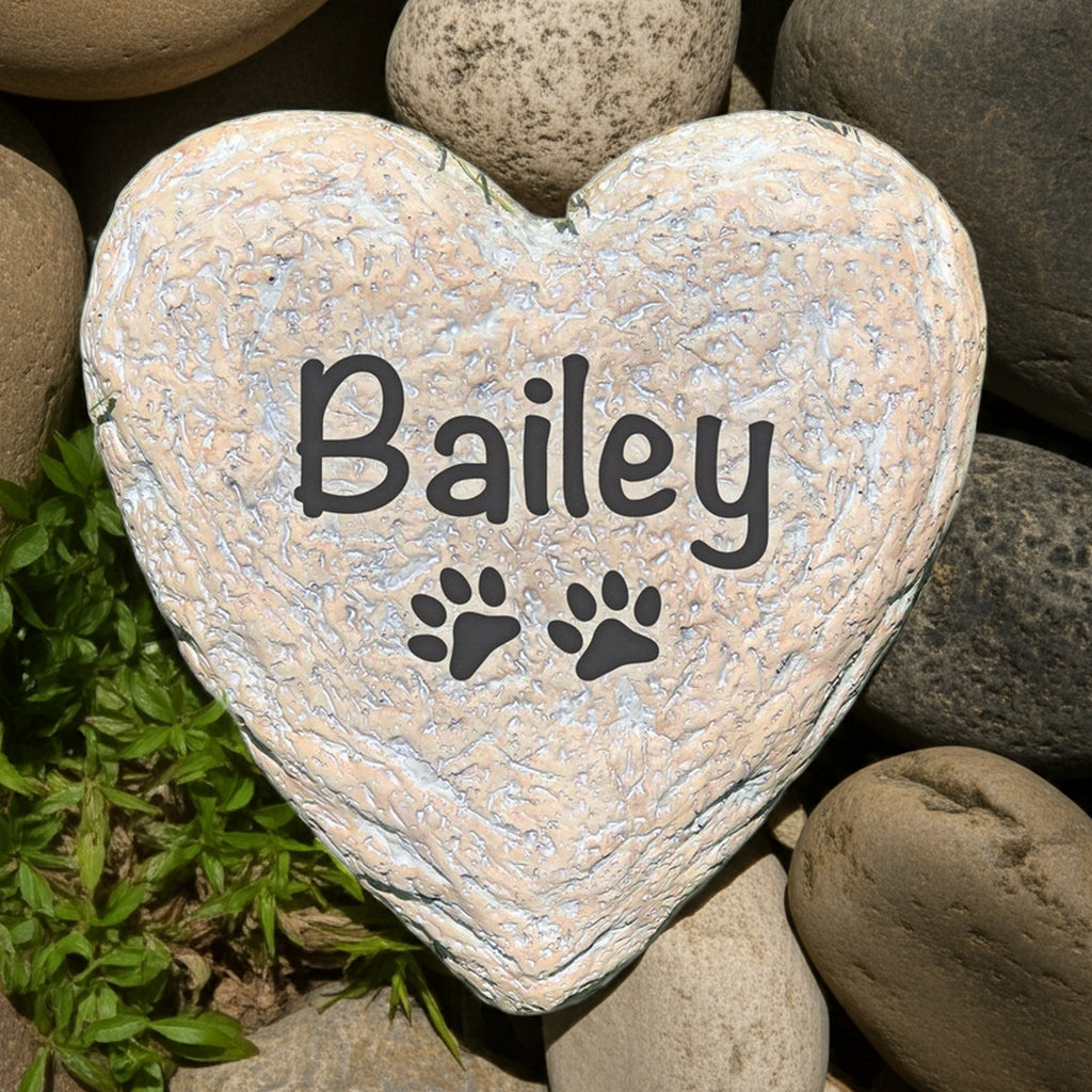 Heart-shaped personalized pet memorial stone with paw prints and pet name Bailey