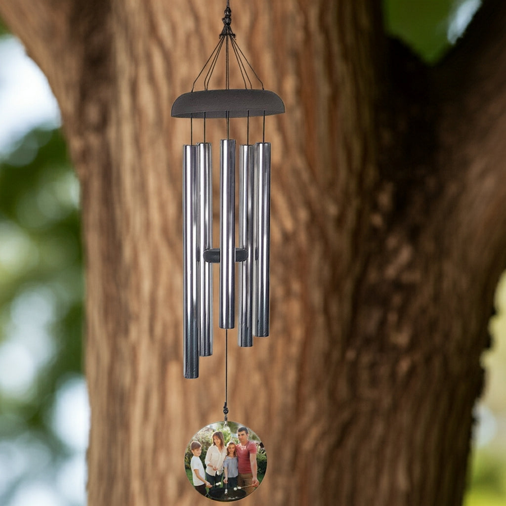 Personalized photo memorial wind chime with silver tubes hanging outdoors on a tree