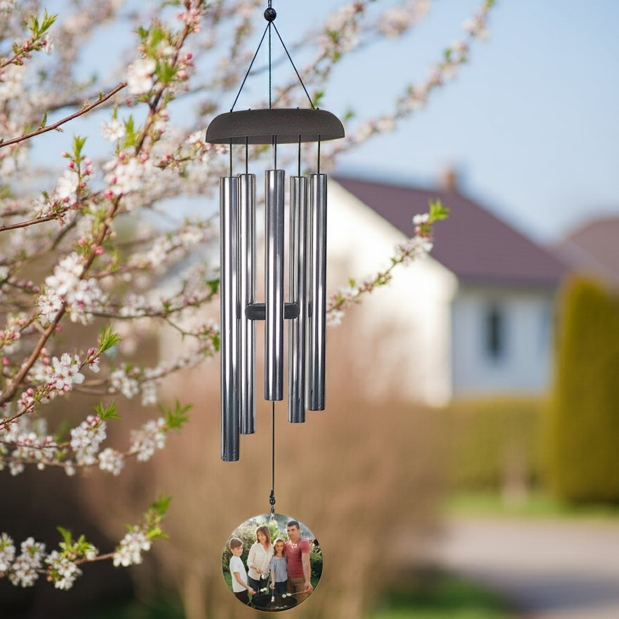 Personalized photo memorial wind chime hanging outdoors with silver tones and family photo charm
