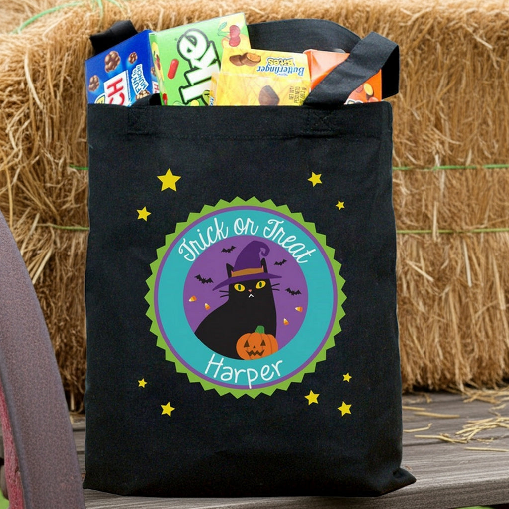 Black Halloween tote with purple chevron panel and cat design reading Sophia filled with candy personalized trick or treat bag