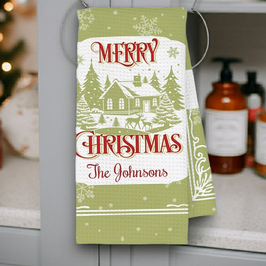 Personalized waffle weave Christmas kitchen towel featuring Merry Christmas design with a cozy cabin and snowy trees