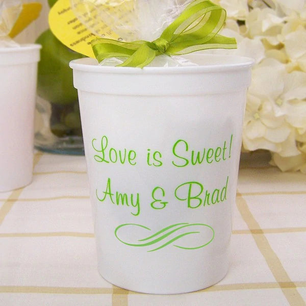 White 16 oz. stadium cups personalized with love is sweet text and bride and groom names in neon green imprint color