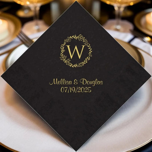 Black paper wedding dinner napkin personalized with ivy wreath monogram initial and bride and groom name in gold print