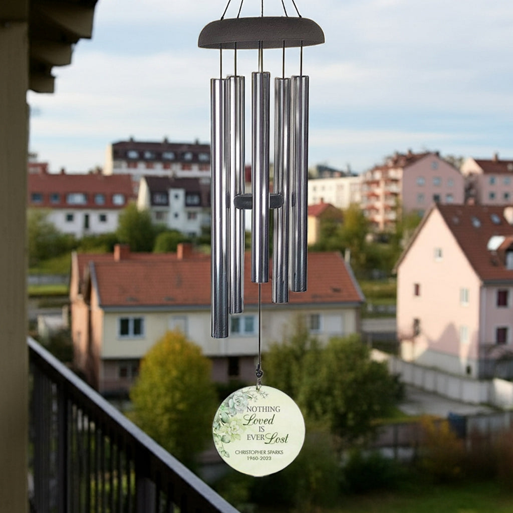 Personalized wind chime memorial with metal tubes and engraved round pendant hanging outdoors