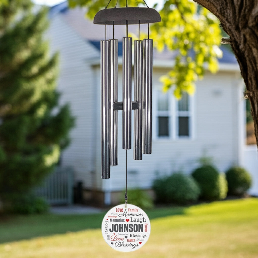 Personalized wind chime with silver tubes and custom name wind sail hanging outdoors