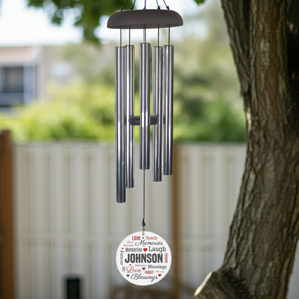 Personalized wind chime with silver tubes and custom name printed on word art wind sail hanging outdoors
