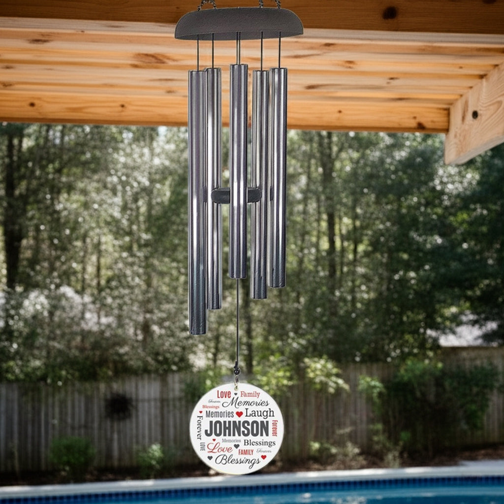Personalized wind chime with silver tubes and custom name round wind saile hanging outdoors