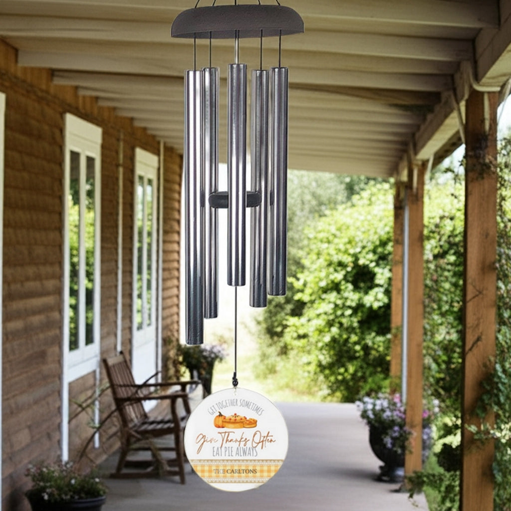Wind chime hanging on porch with metal tubes and round decorative personalized wind sail