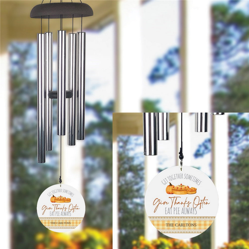 Personalized wind chime with metal tubes and a round custom message wind sail hanging outdoors
