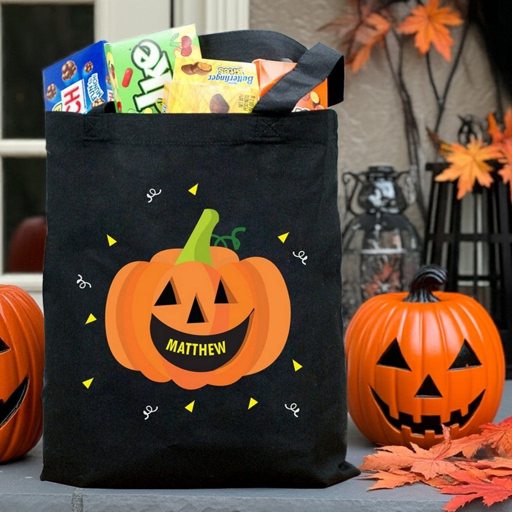 Black pumpkin personalized trick or treat bag with smiling jack o lantern design labeled Matthew and candy inside