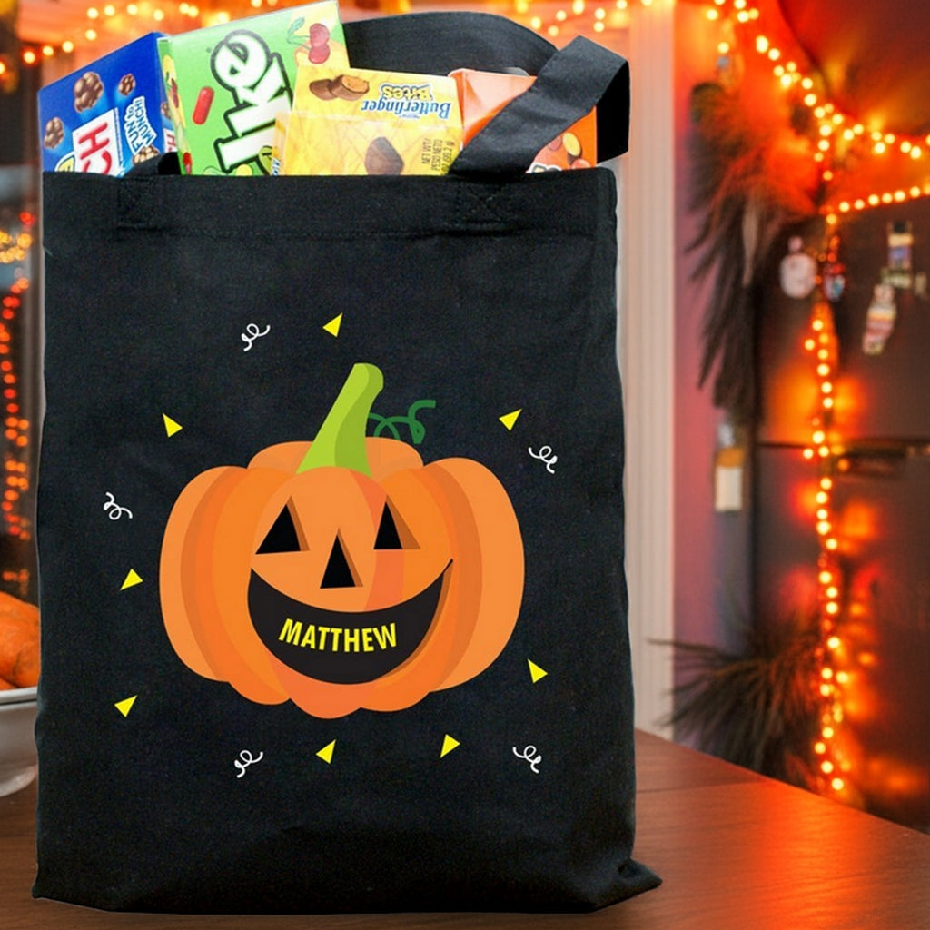 Black candy filled tote with smiling jack o lantern and name Matthew on front pumpkin personalized trick or treat bag