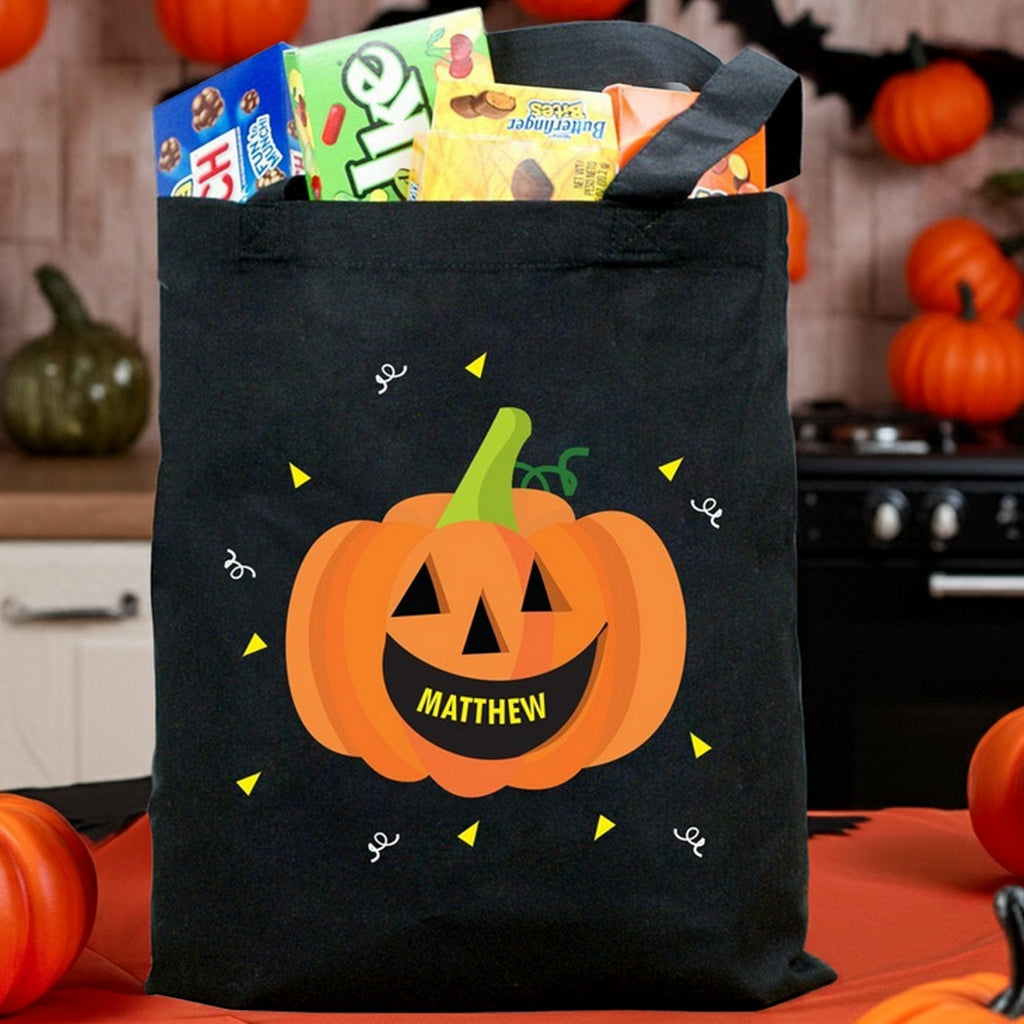 Black tote pumpkin personalized trick or treat bag with smiling jack o lantern and name Matthew filled with candy