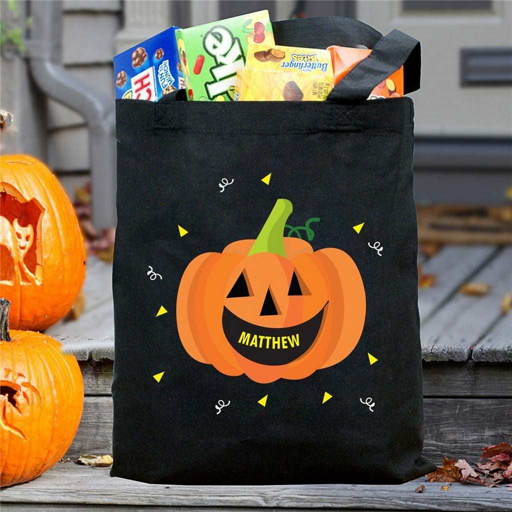 Black tote with smiling jack o lantern and name Matthew filled with candy pumpkin personalized trick or treat bag
