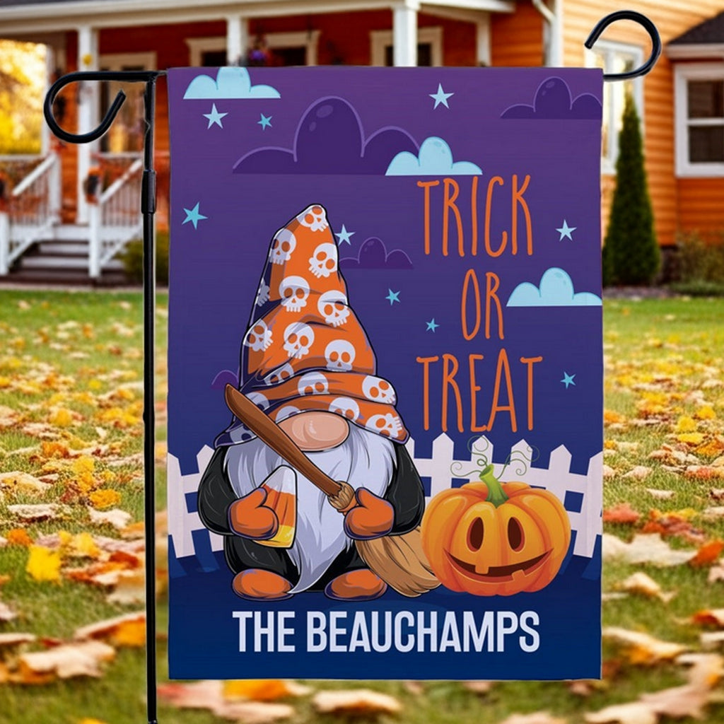 Halloween garden flag with gnome in skull patterned witch hat holding broom beside carved pumpkin and Trick or Treat text