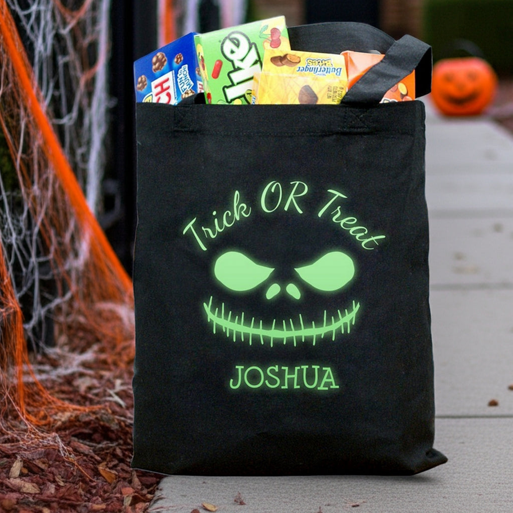 Black tote with glowing green monster face and name Joshua with candy glow in the dark monster personalized trick or treat bag