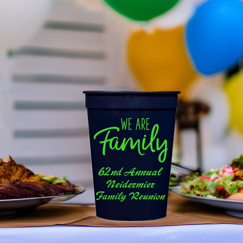 A navy plastic cup personalized for family reunion with "We Are Family" grahic and 3 lines of script text in neon green print