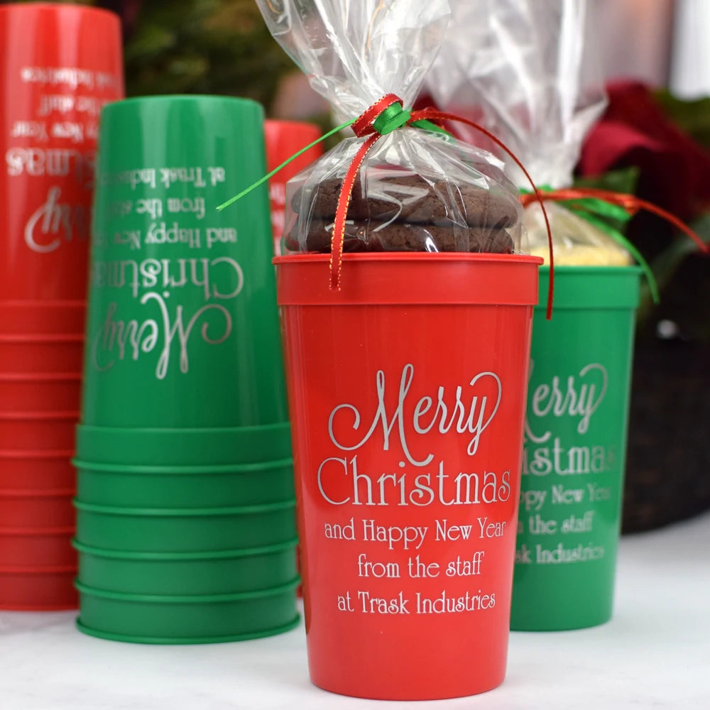 Red and green large stadium cups personalized with merry christmas design and custom text in silver print filled with christmas cookie favors