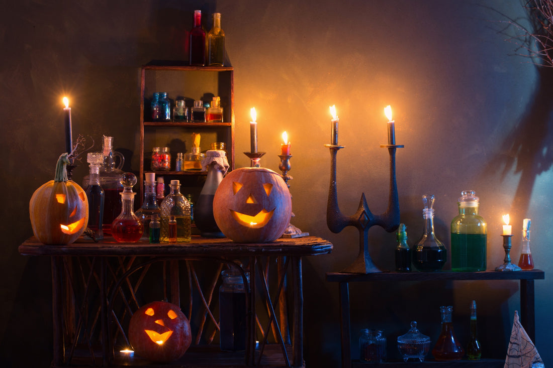 Indoor Halloween party decorations with pumpkins, magic potions and candles