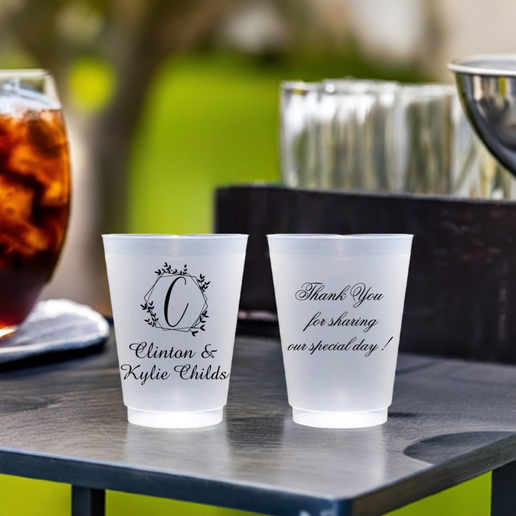 Personalized frosted plastic wedding cups on table at outdoor wedding reception