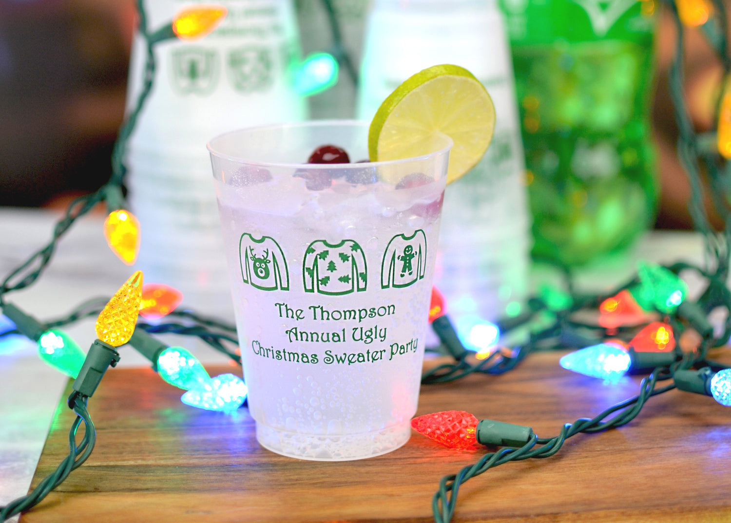 Frosted plastic christmas cups personalized with design and custom text in green print on holiday drink table