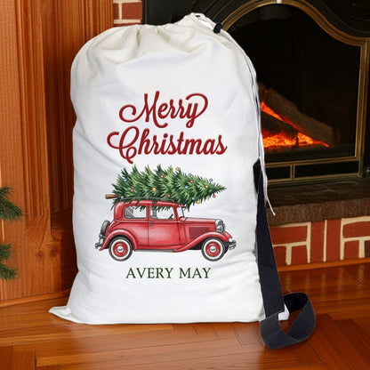Personalized Santa sack with Merry Christmas design and red vintage truck carrying a Christmas tree