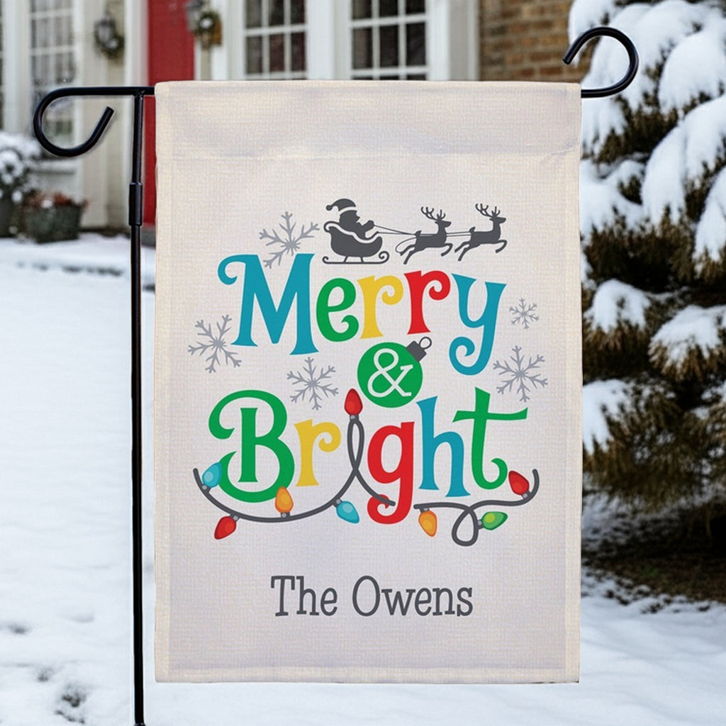 Christmas garden flag personalized with colorful Merry & Bright design featuring snowy background and festive lights