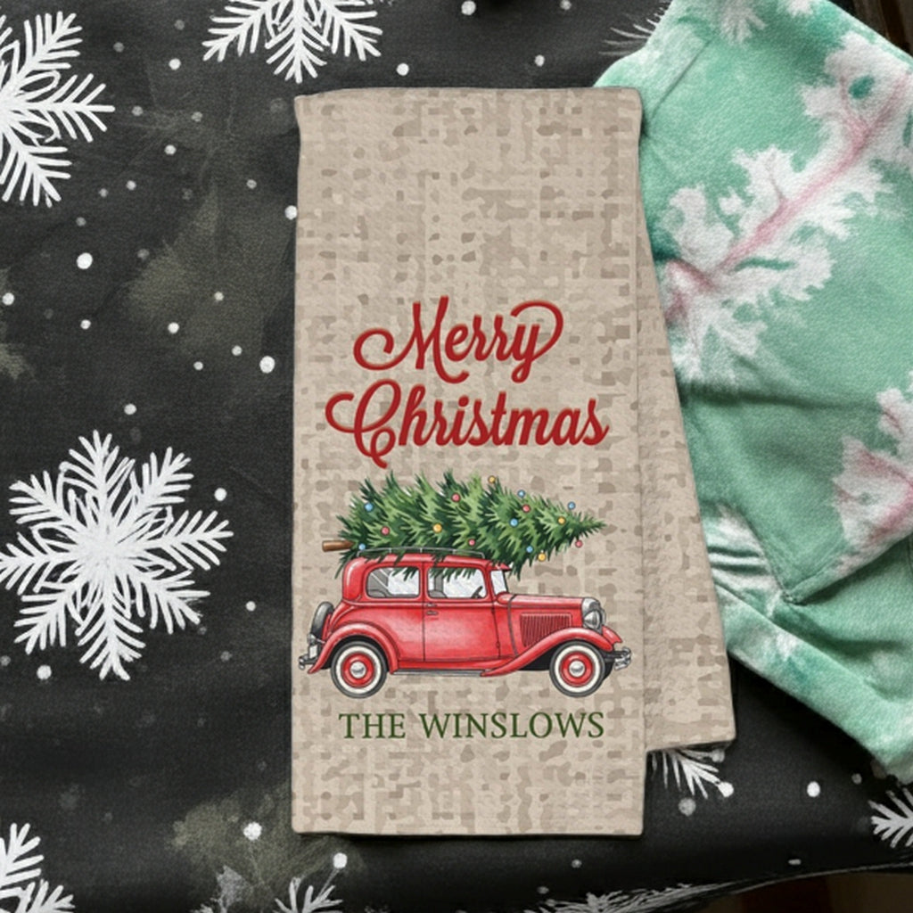 Merry Christmas kitchen towel featuring a vintage red truck carrying a Christmas tree personalized with name