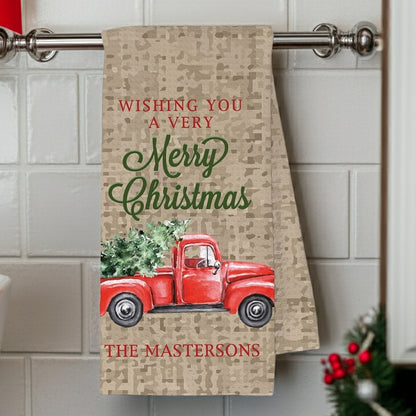 Christmas kitchen towel featuring a red truck and festive holiday wishes personalized with family name